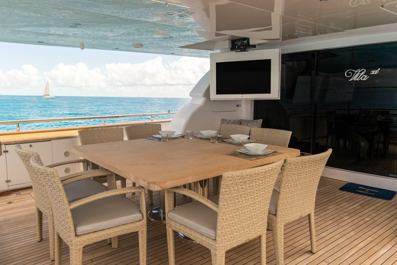 a table and chairs on a deck aboard VITA XL Yacht for Sale