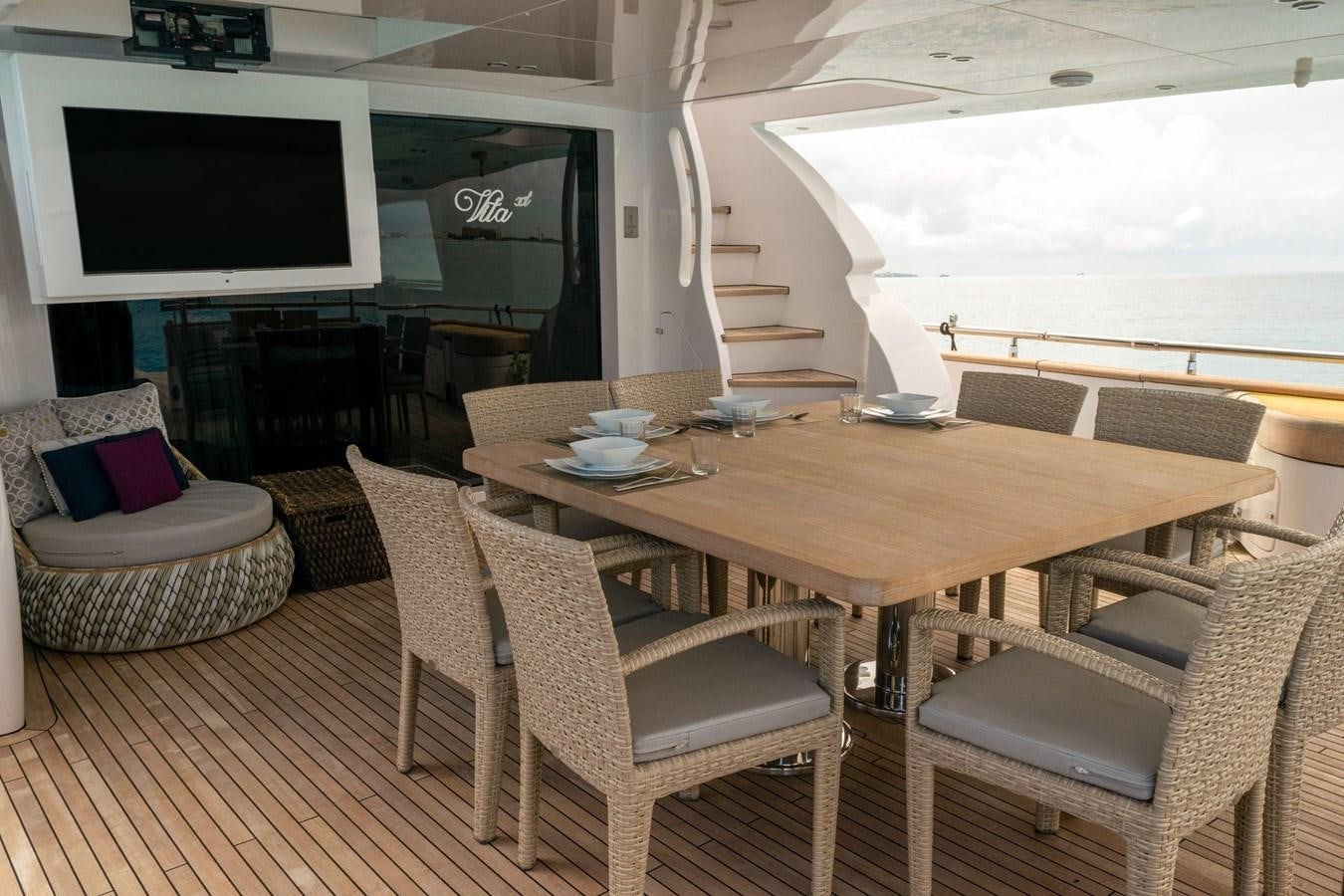 a table with chairs and a television aboard VITA XL Yacht for Sale