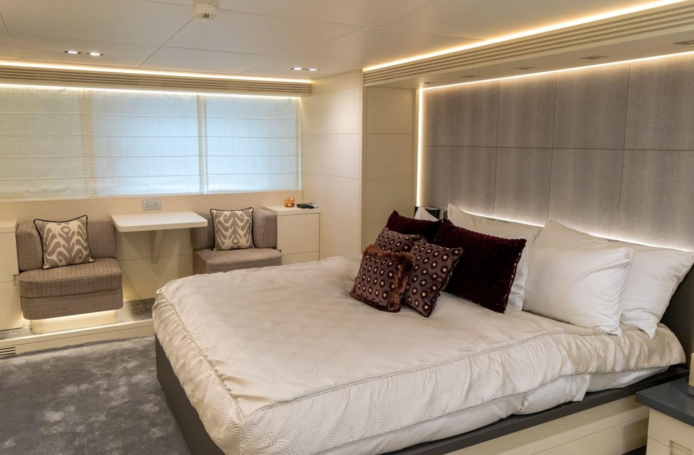 a bed with pillows and a chair aboard VITA XL Yacht for Sale