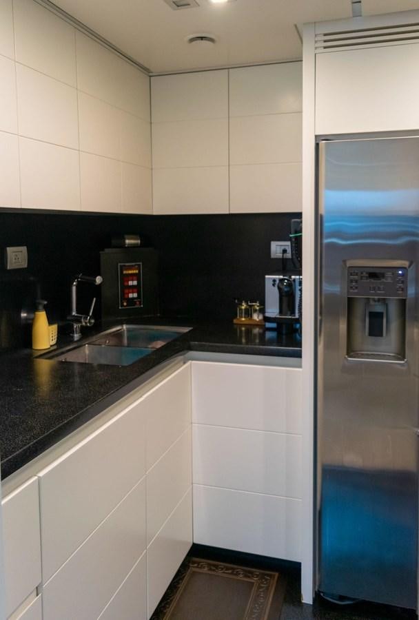 a kitchen with a sink and a refrigerator aboard VITA XL Yacht for Sale