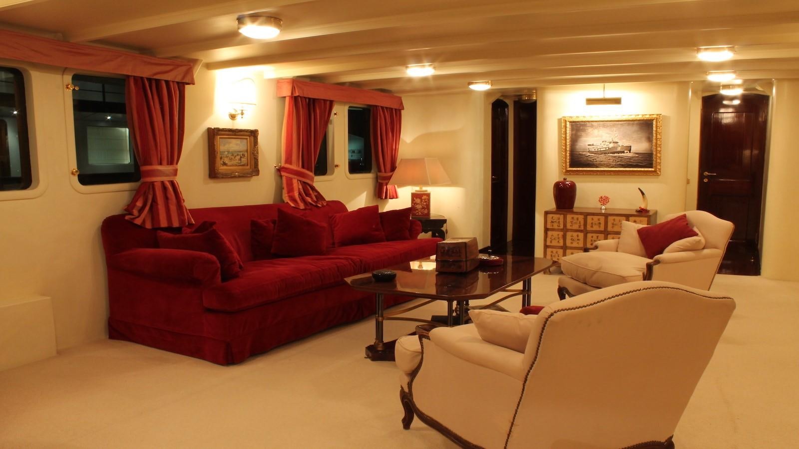 a living room with red couches aboard DP MONITOR Yacht for Sale