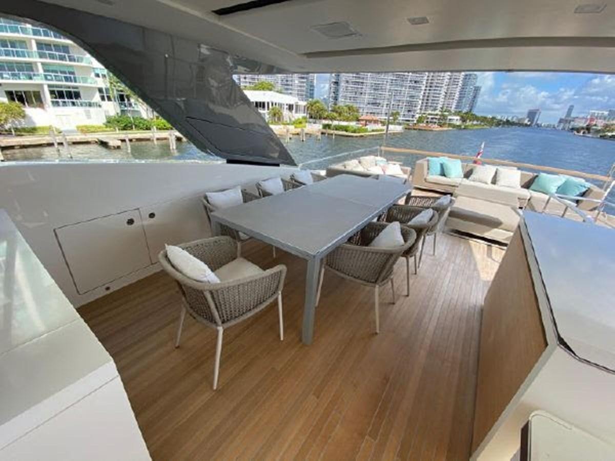 a room with a table chairs and a large building with a view of the water aboard ASTONISH Yacht for Sale