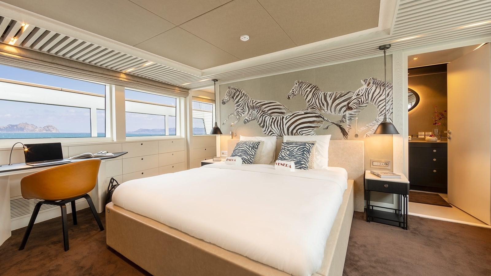a bedroom with a bed and desk aboard BLONDIE Yacht for Sale