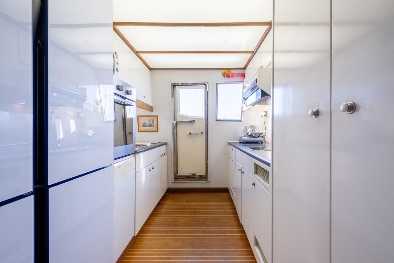 a kitchen with white cabinets aboard TIENNA Yacht for Sale