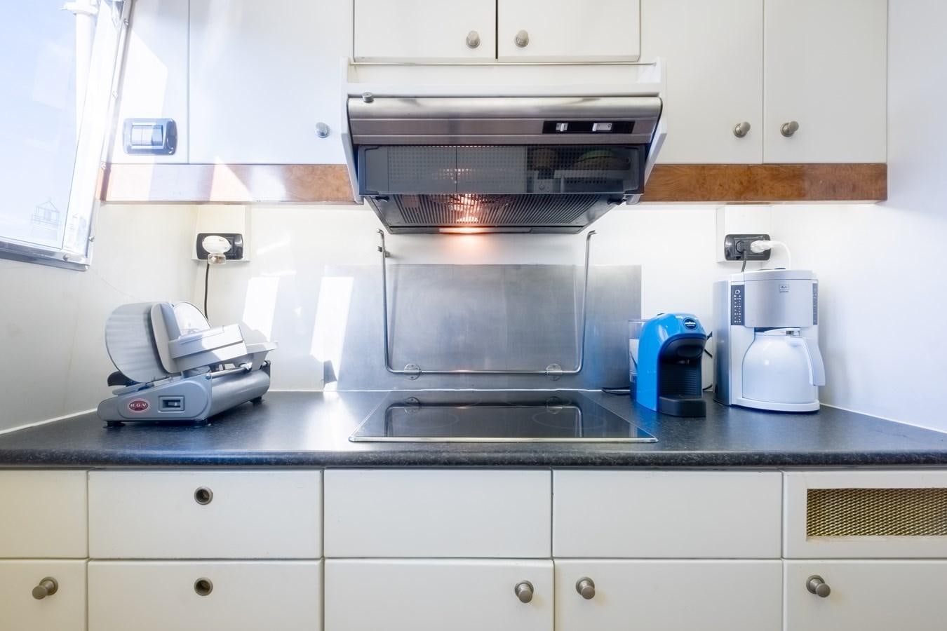 a kitchen with a stove and a coffee maker aboard TIENNA Yacht for Sale