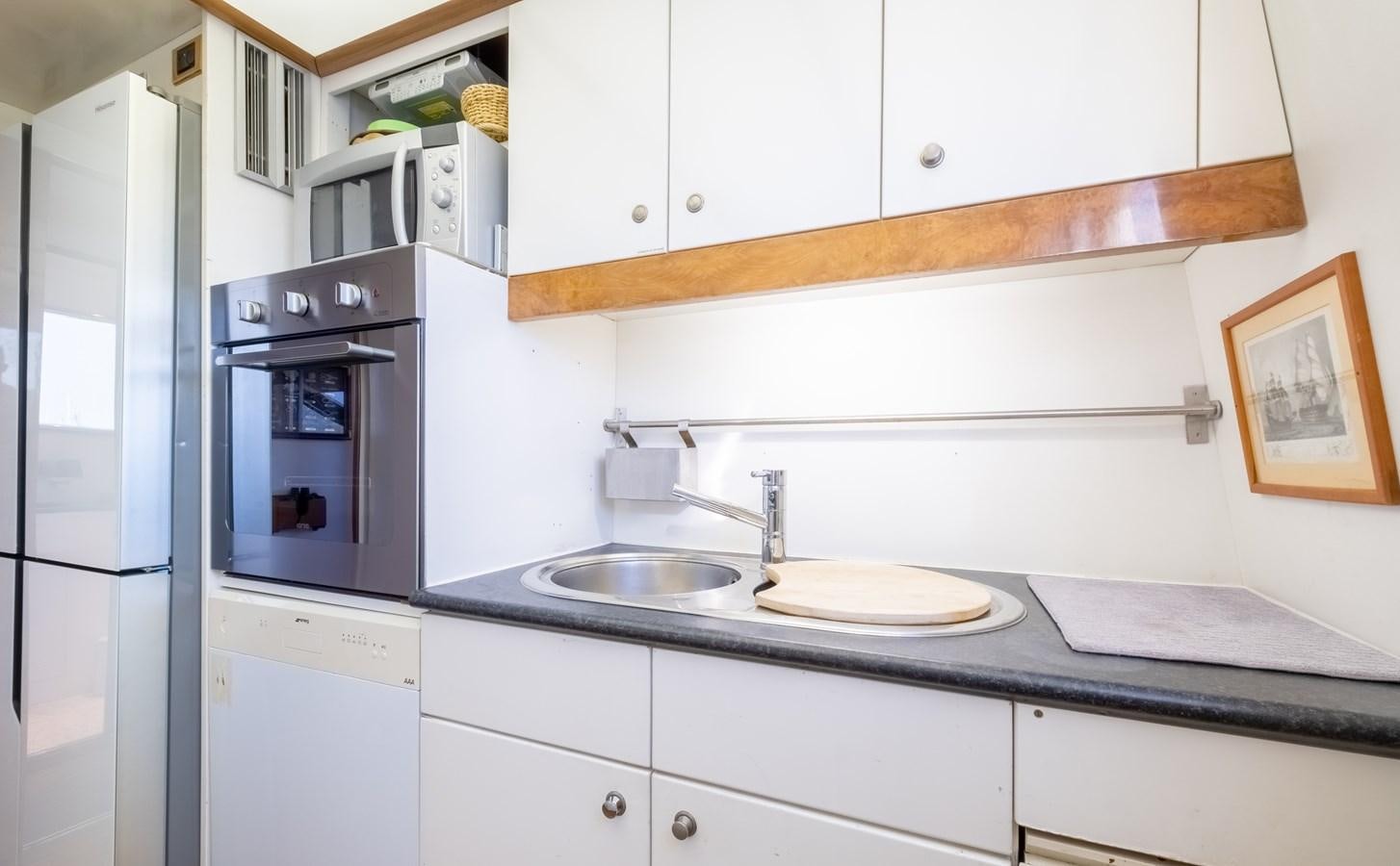 a kitchen with white cabinets aboard TIENNA Yacht for Sale