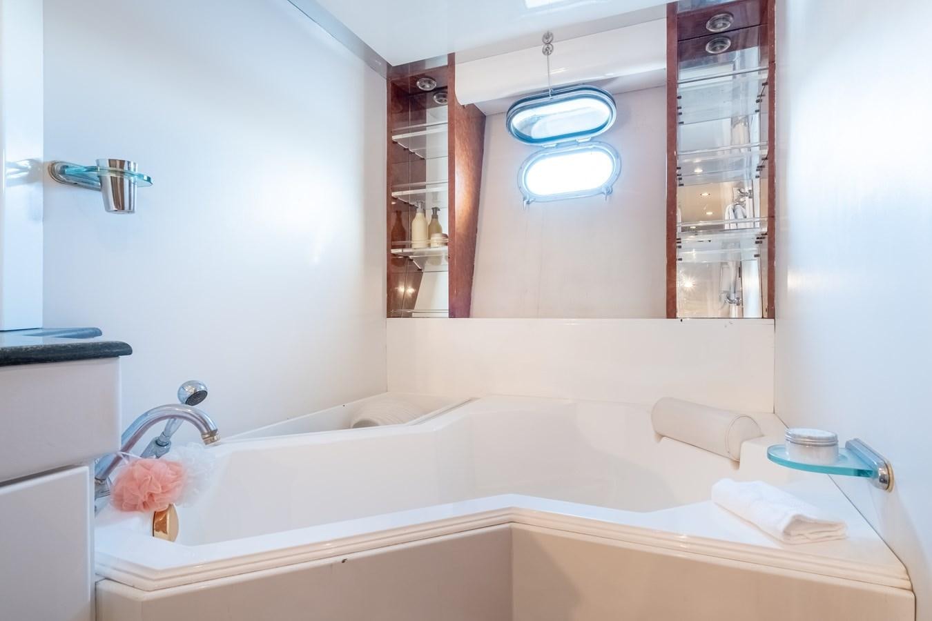 a bathroom with a tub sink and mirror aboard TIENNA Yacht for Sale