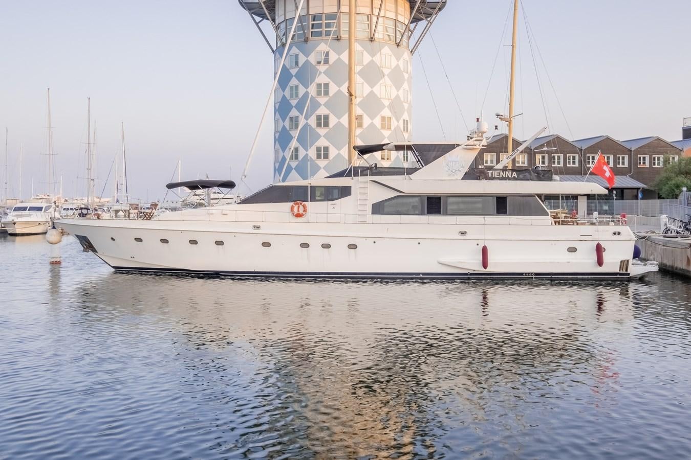 a large white boat in a harbor aboard TIENNA Yacht for Sale