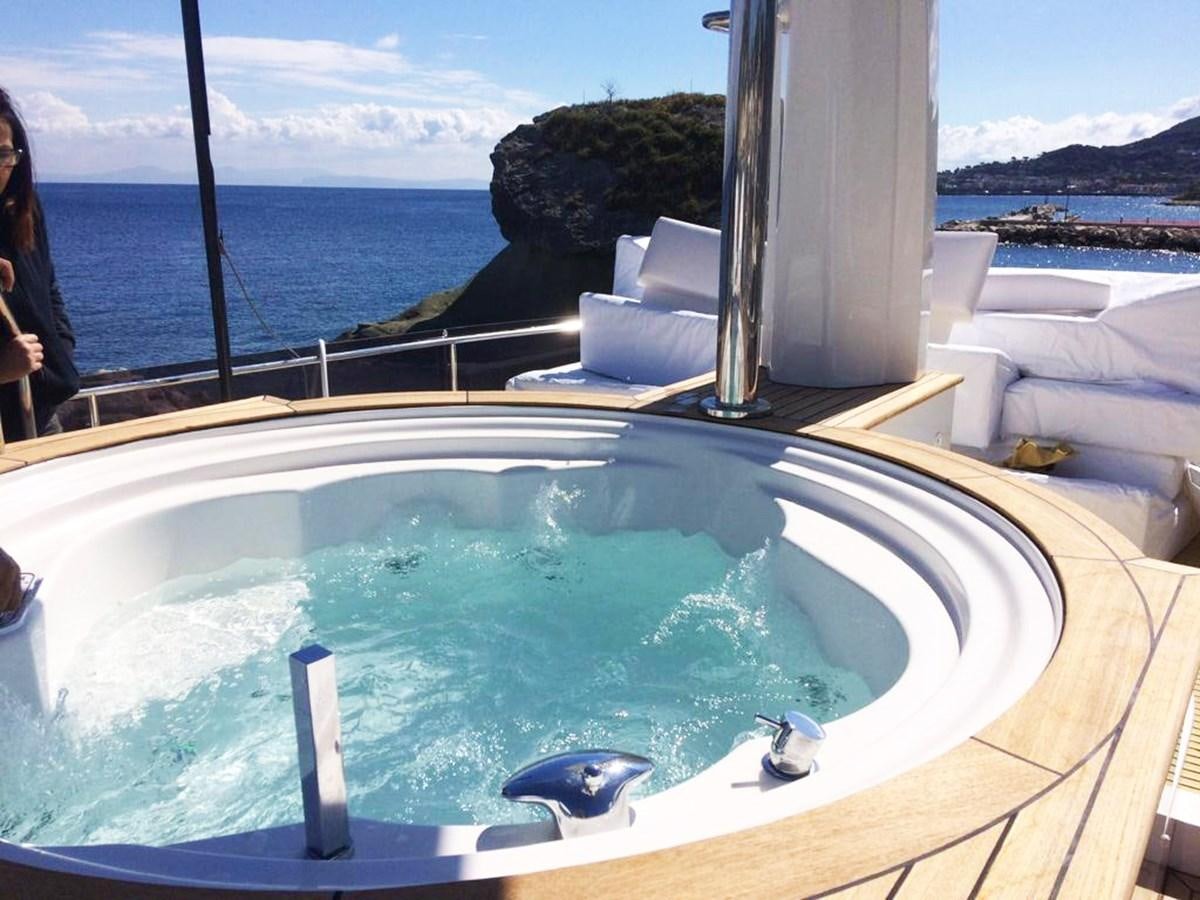 a swimming pool with a view of the ocean and mountains in the background aboard PALGREMAT Yacht for Sale