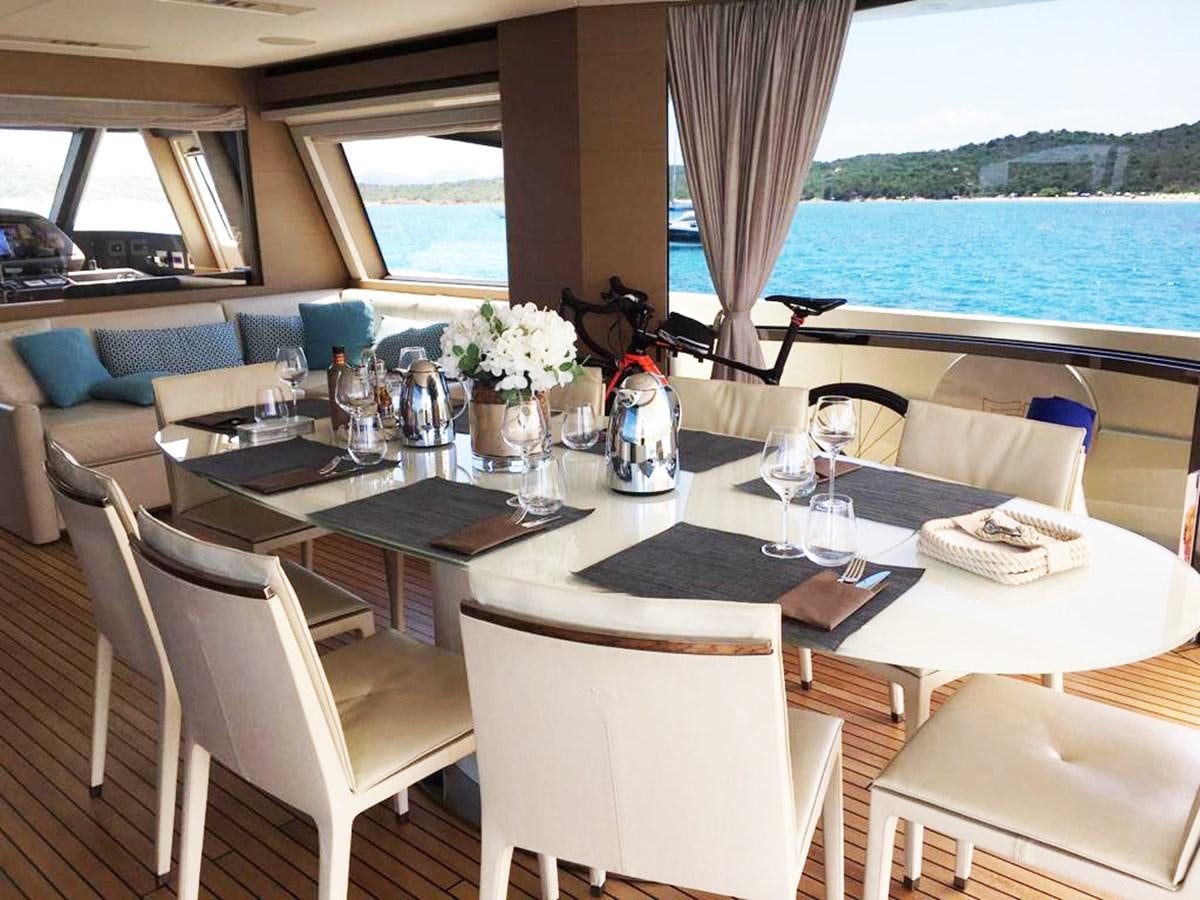 a table with chairs and a vase of flowers on it aboard PALGREMAT Yacht for Sale
