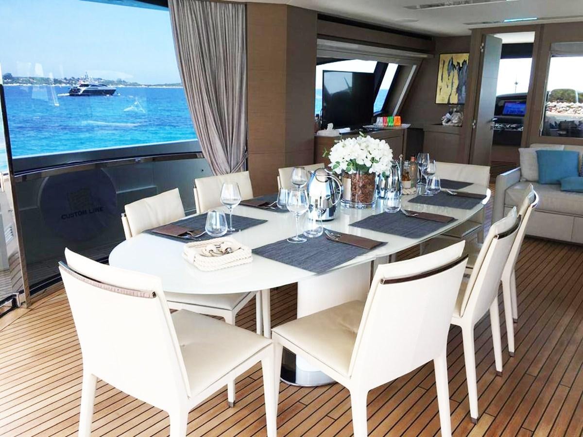 a table with chairs and a view of the ocean aboard PALGREMAT Yacht for Sale