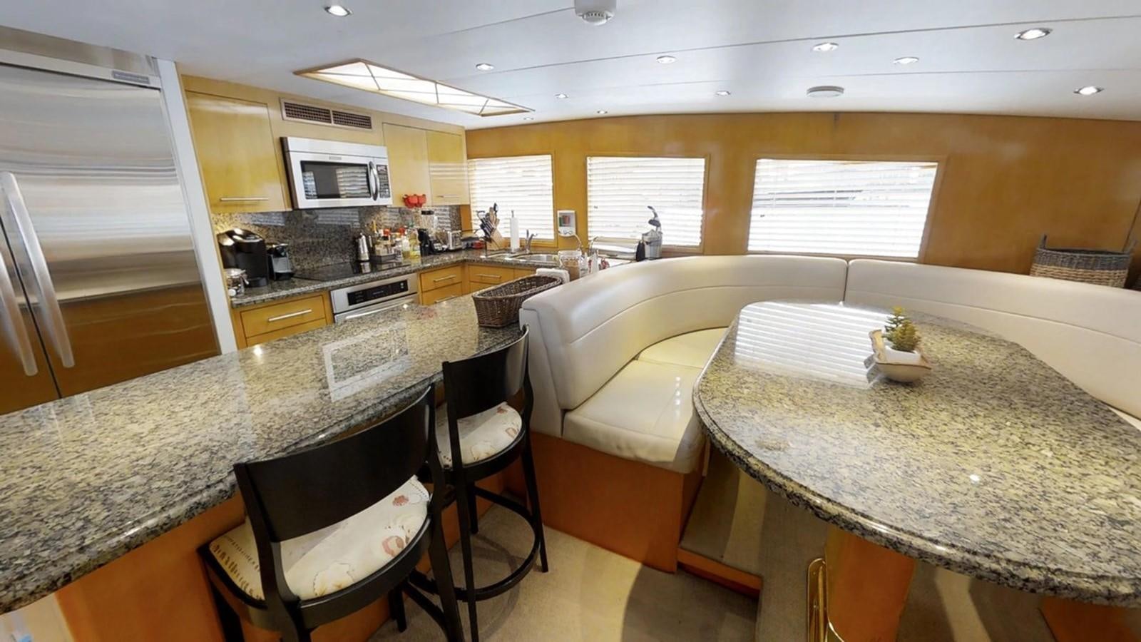 a kitchen with a table and chairs aboard 92' HATTERAS Yacht for Sale