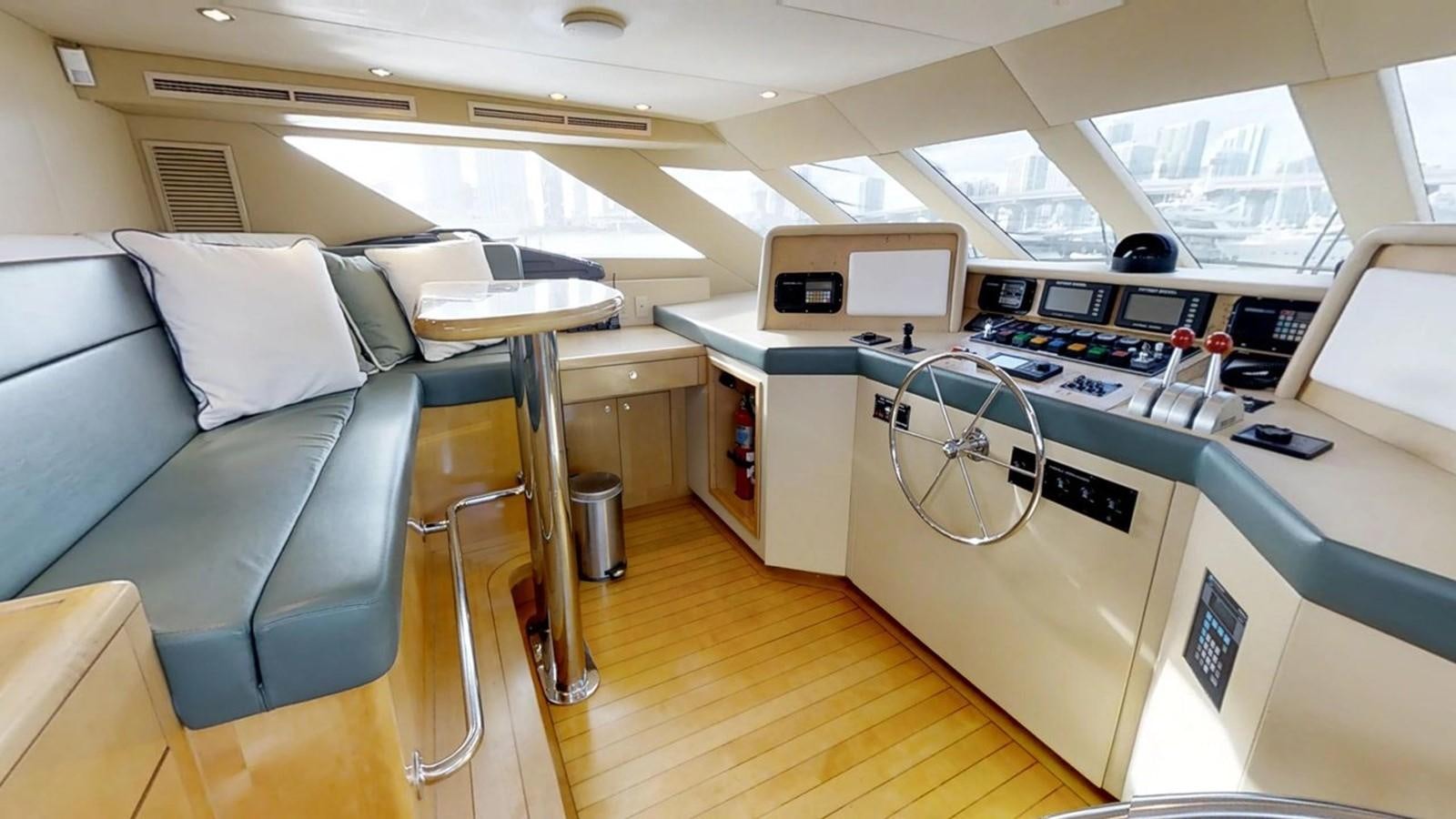 a room with a couch and a table with chairs and computers aboard 92' HATTERAS Yacht for Sale