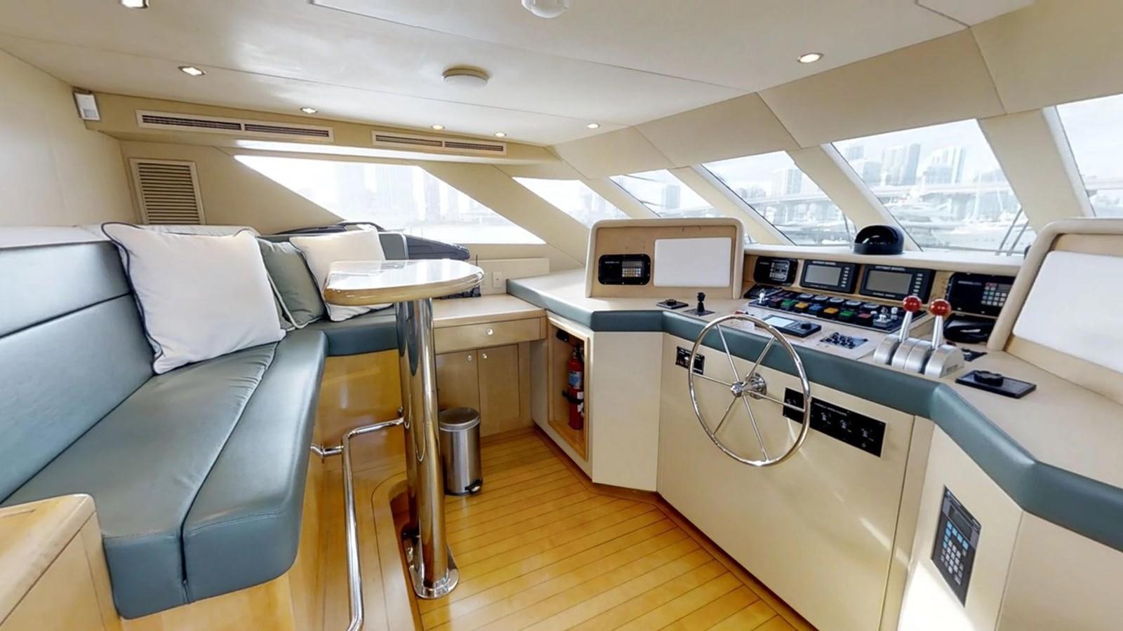 a room with a couch and a table with chairs and a television aboard 92' HATTERAS Yacht for Sale