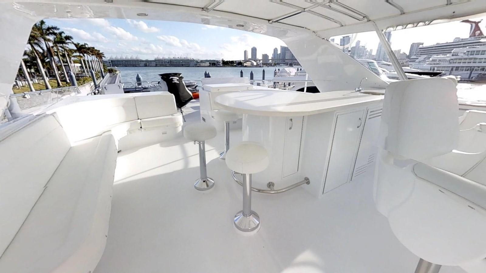 a room with white chairs and tables aboard 92' HATTERAS Yacht for Sale