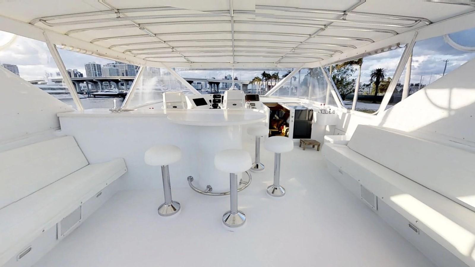 a room with white chairs and tables aboard 92' HATTERAS Yacht for Sale