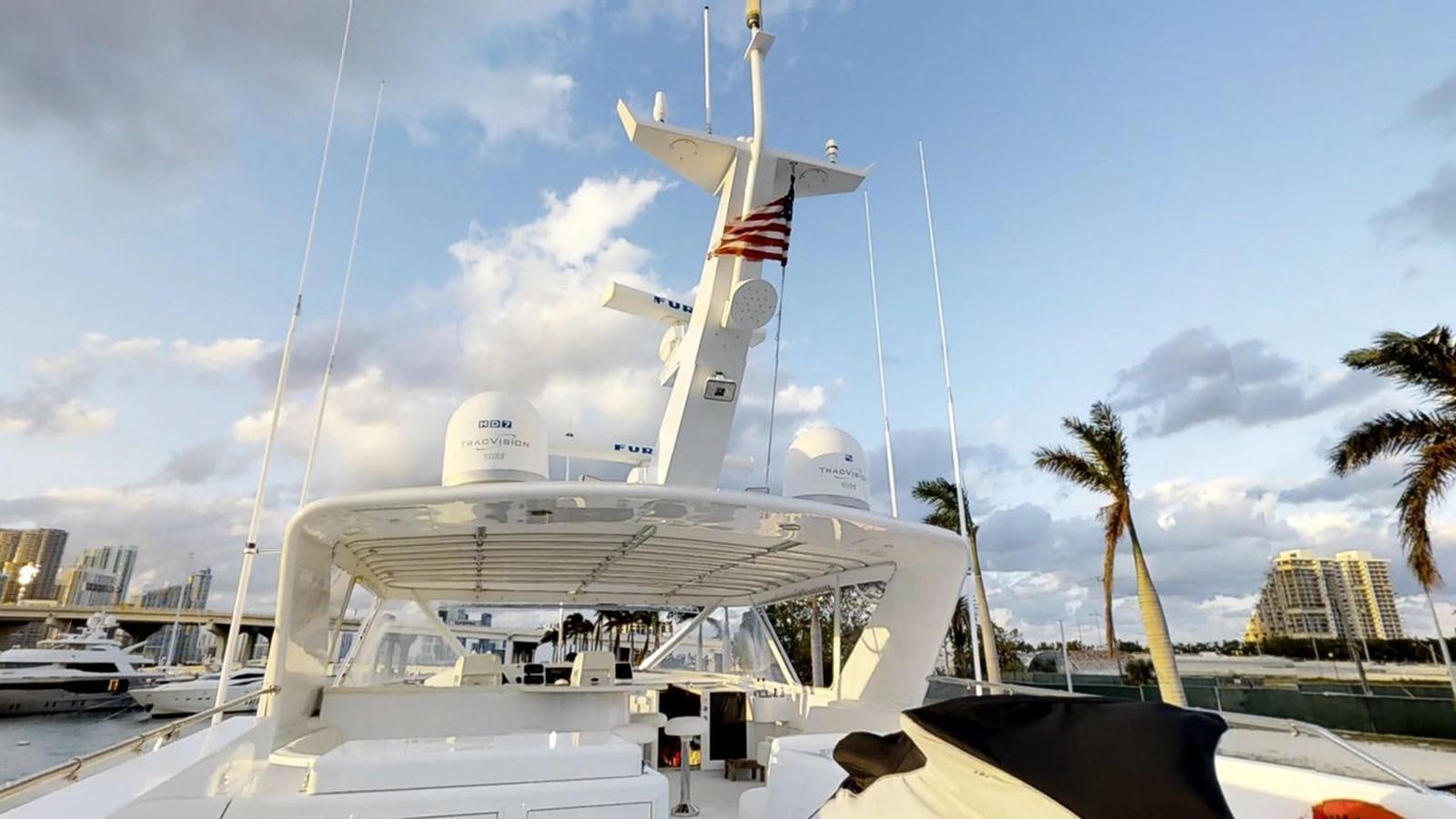 a large white boat with flags on it aboard 92' HATTERAS Yacht for Sale
