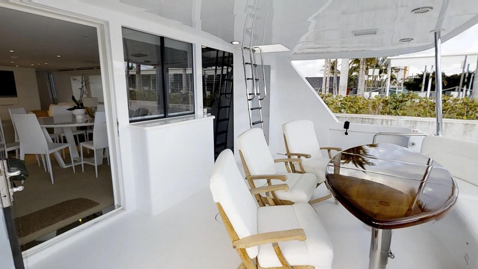 a room with tables and chairs aboard 92' HATTERAS Yacht for Sale