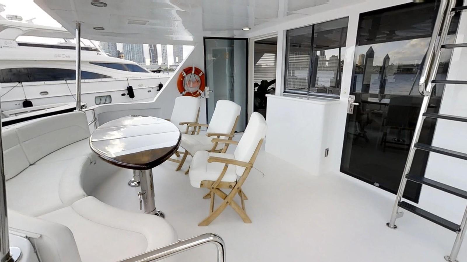 a room with a table and chairs aboard 92' HATTERAS Yacht for Sale