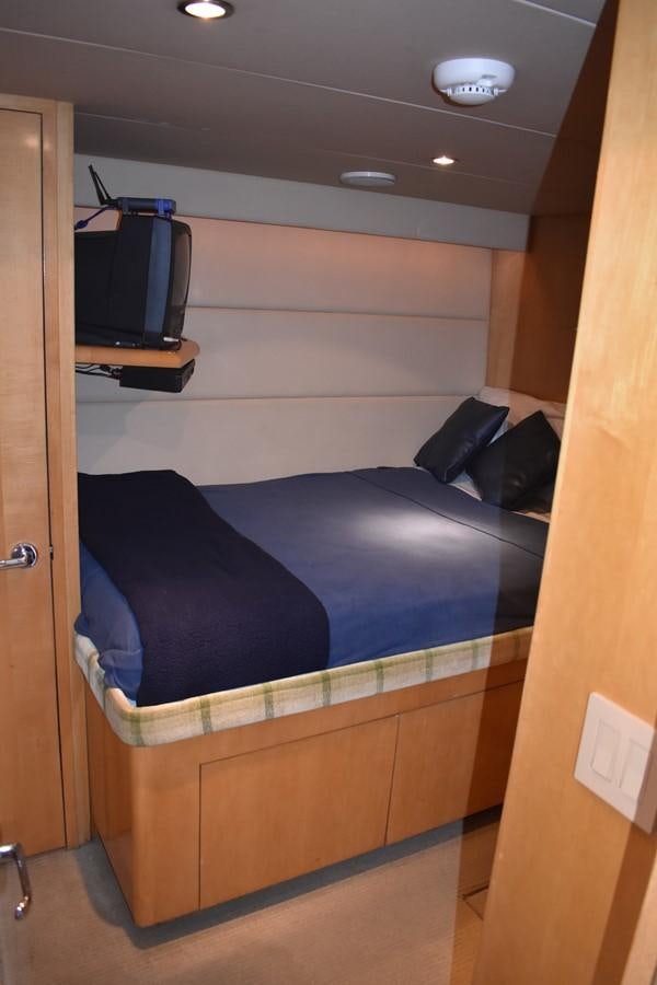 a bed with a television on top aboard 92' HATTERAS Yacht for Sale