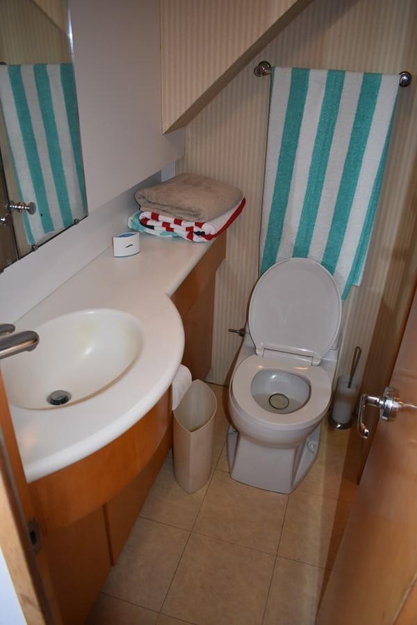 a bathroom with a toilet and sink aboard 92' HATTERAS Yacht for Sale