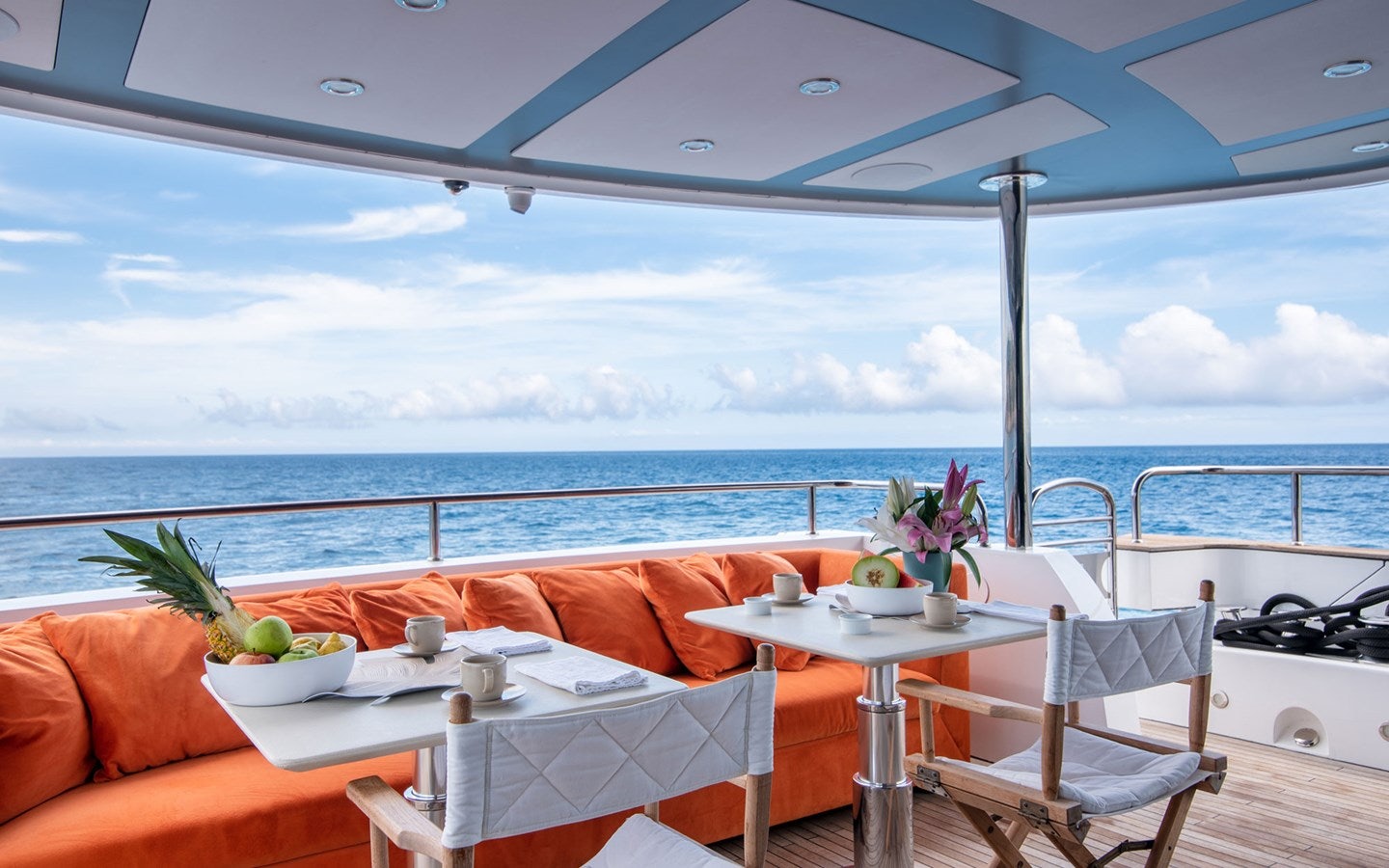 a table and chairs on a balcony overlooking the ocean aboard MIRKA Yacht for Charter