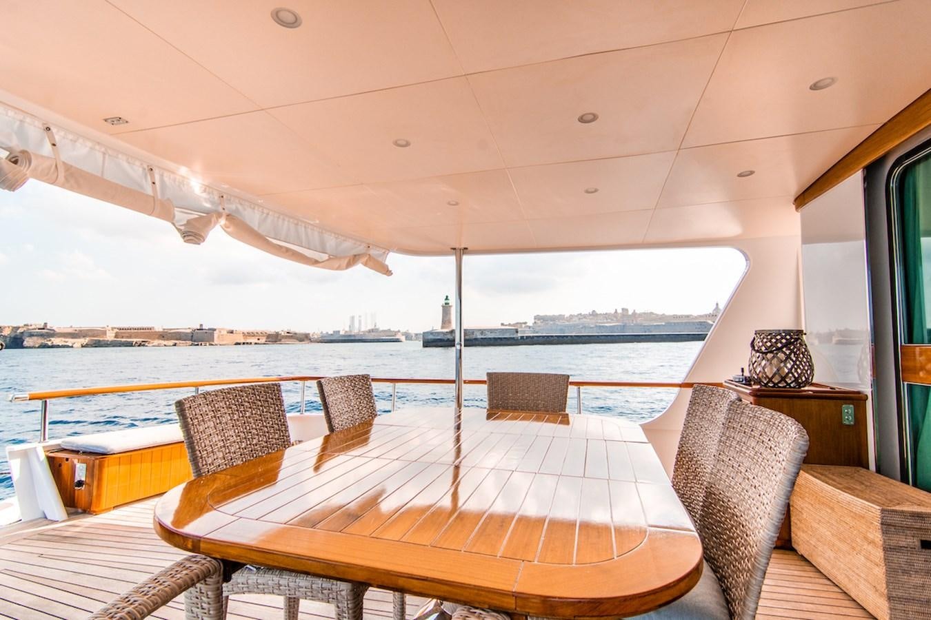 a table and chairs on a deck aboard A&A Yacht for Sale
