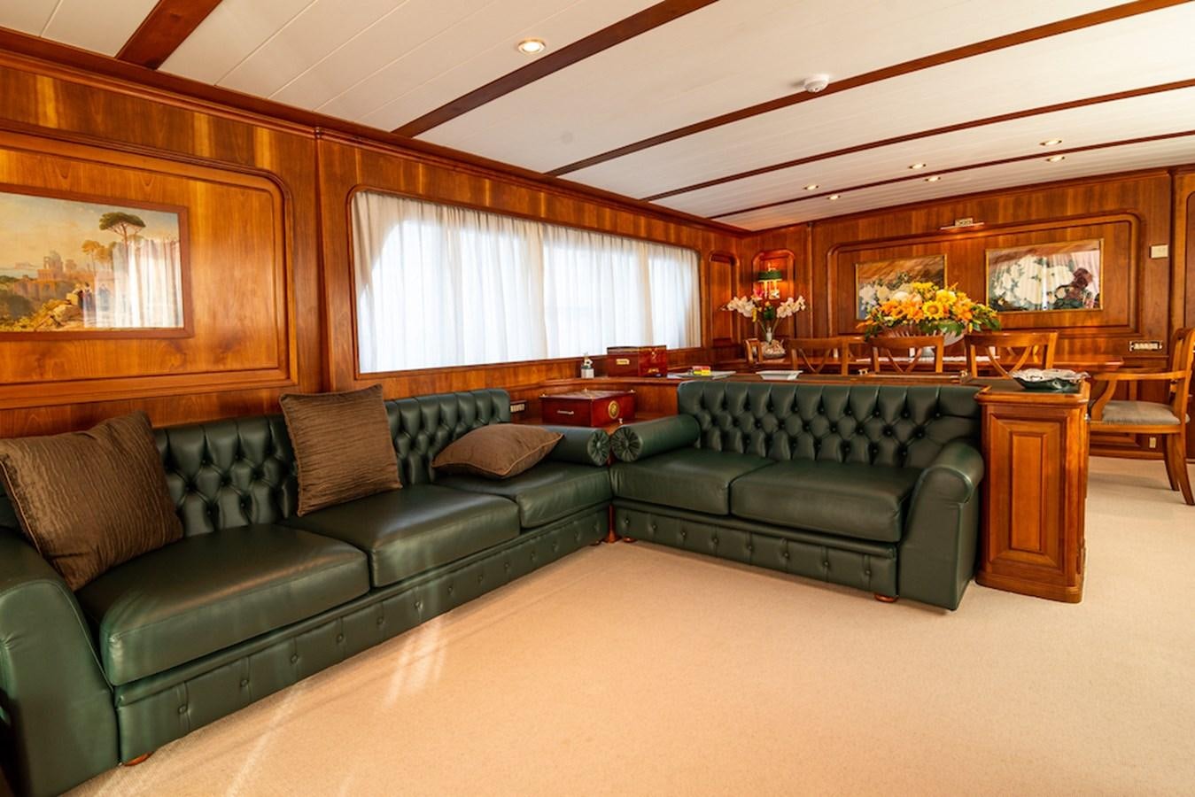 a living room with a green couch aboard A&A Yacht for Sale