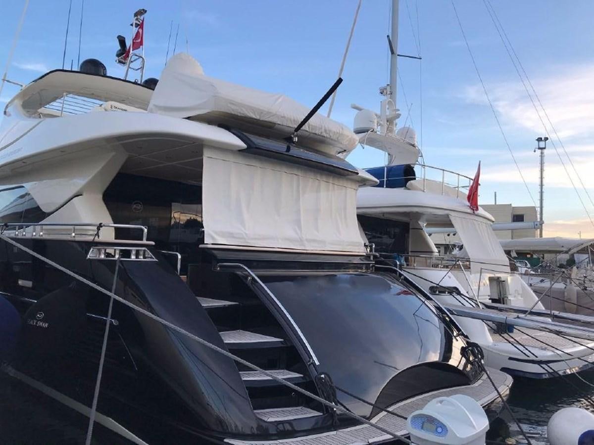a boat with a flag on the front aboard BLACK SWAN Yacht for Sale