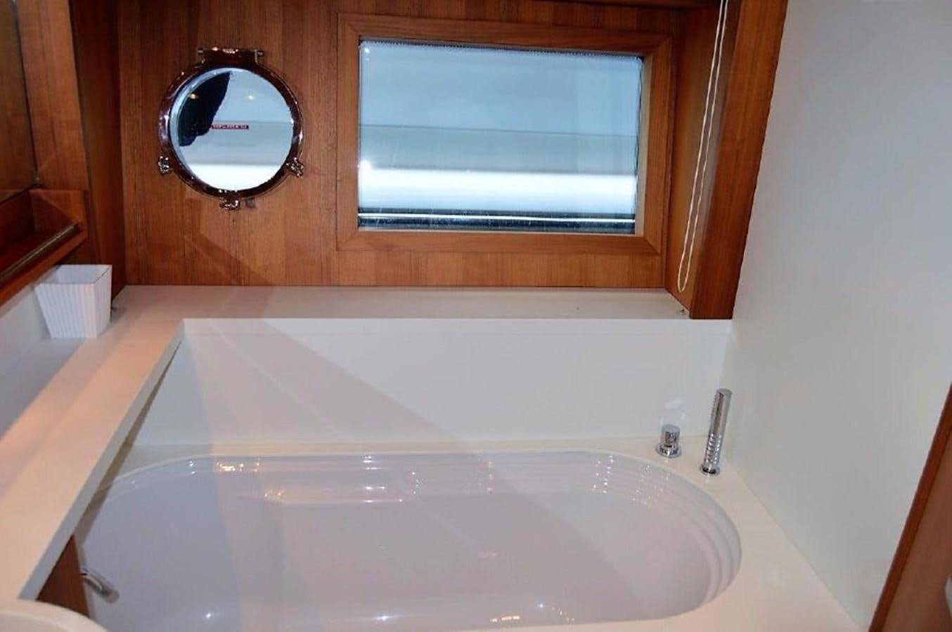 a bathroom with a tub and a mirror aboard BLACK SWAN Yacht for Sale
