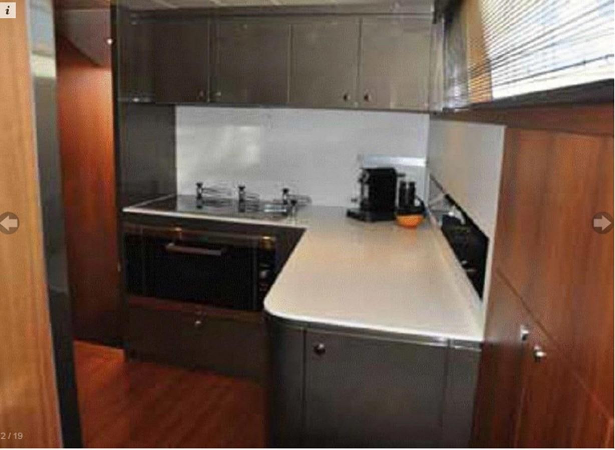 a kitchen with black appliances aboard TAURUS Yacht for Sale
