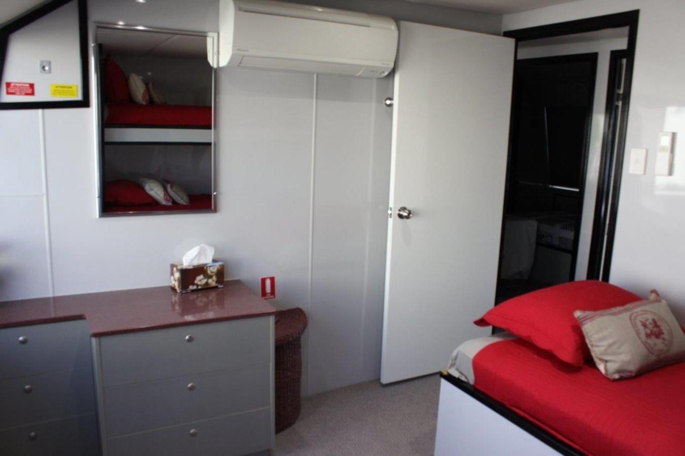a room with a bed and a desk aboard MUSHI KHAN Yacht for Sale
