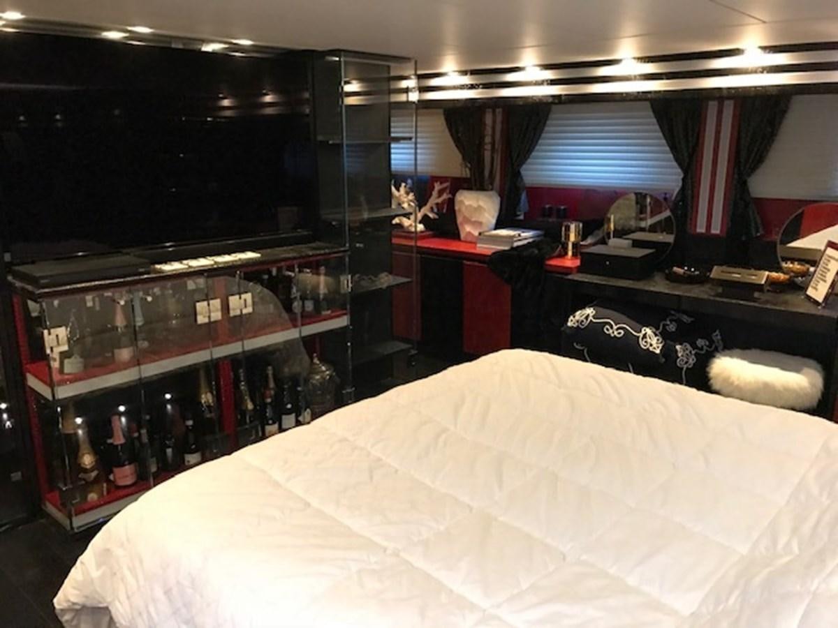 a room with a large display of bottles and a large mirror aboard KISSES Yacht for Sale