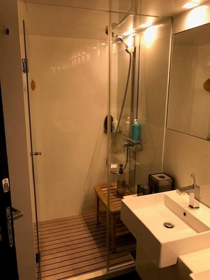 a bathroom with a shower sink and mirror aboard KISSES Yacht for Sale