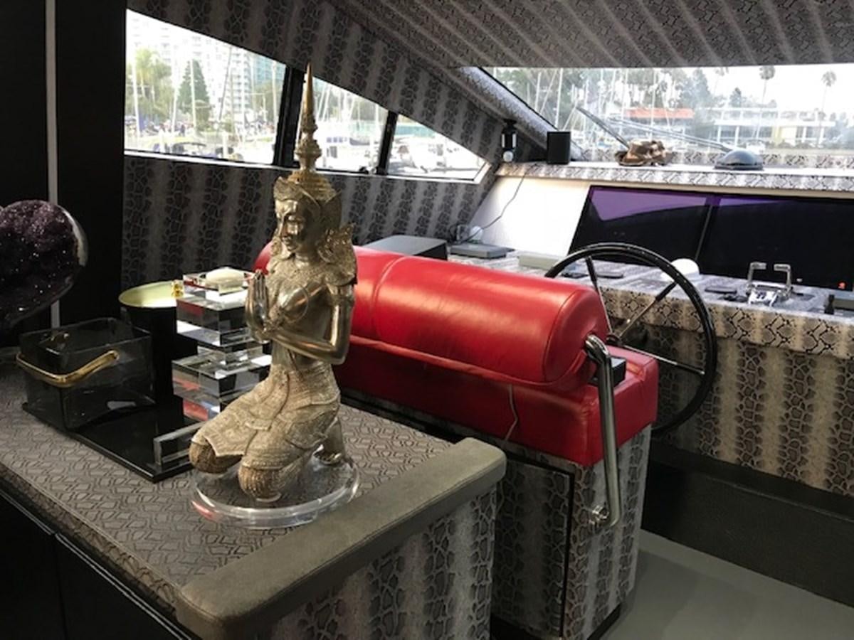 a statue of a person holding a book and a cup on a table aboard KISSES Yacht for Sale