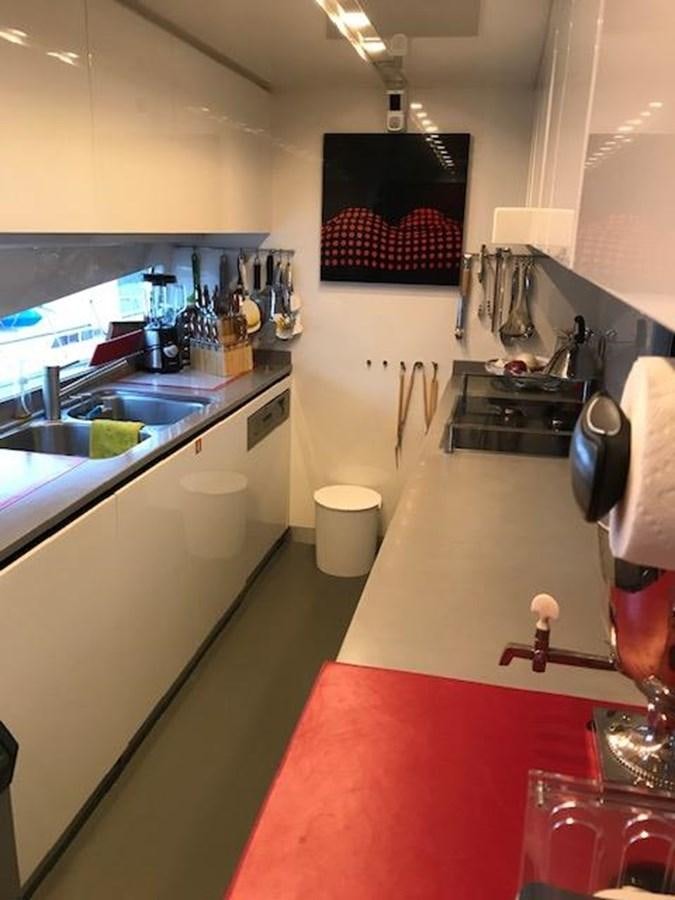 a kitchen with a red counter aboard KISSES Yacht for Sale