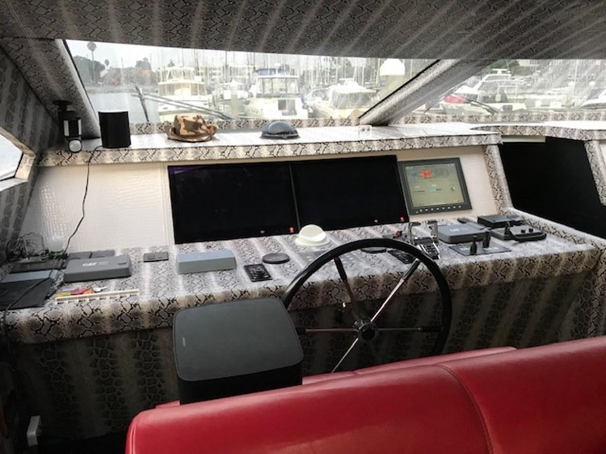 a leather couch in front of a window with a computer on it aboard KISSES Yacht for Sale