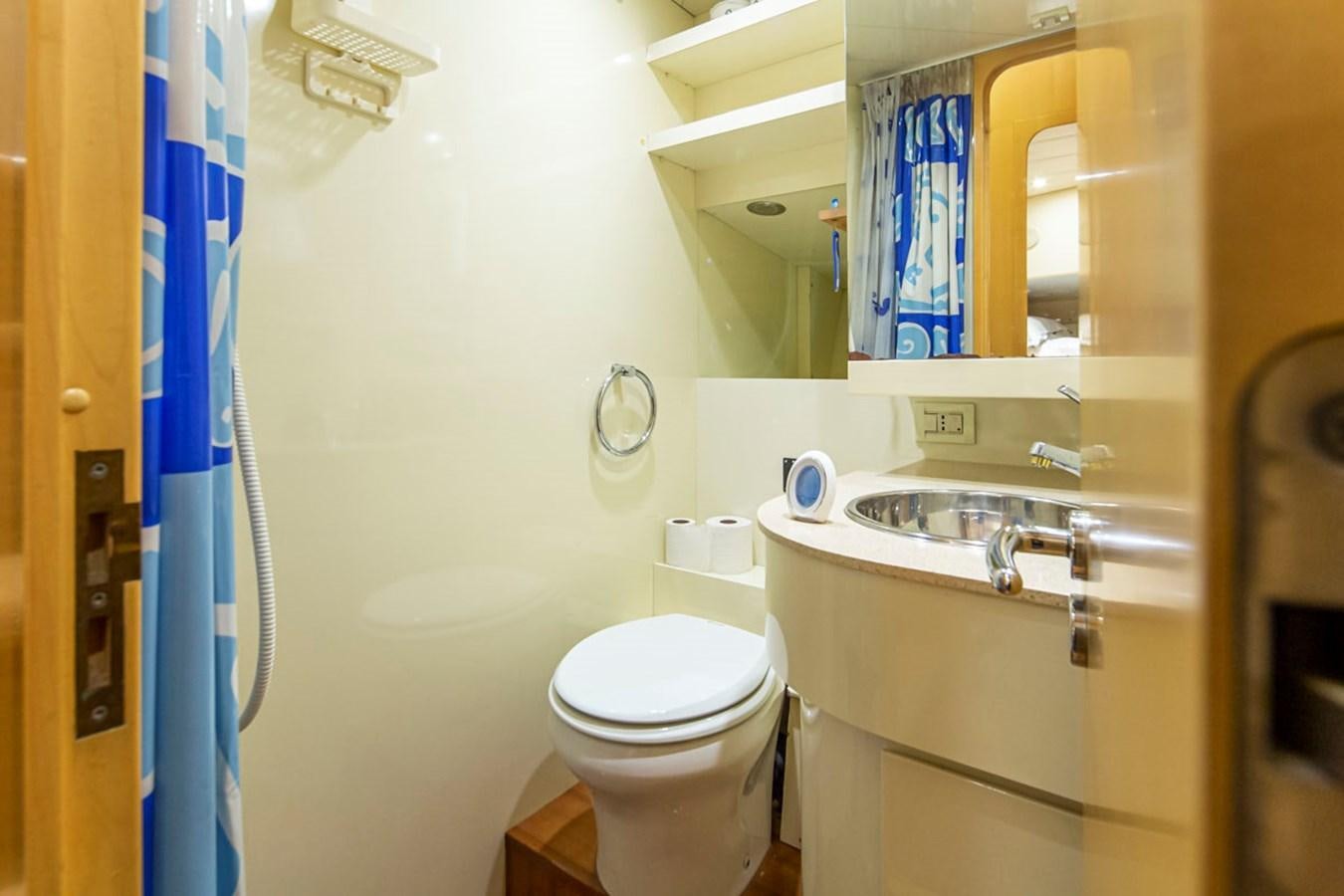 a bathroom with a toilet sink and a mirror aboard WILD WAVES Yacht for Sale