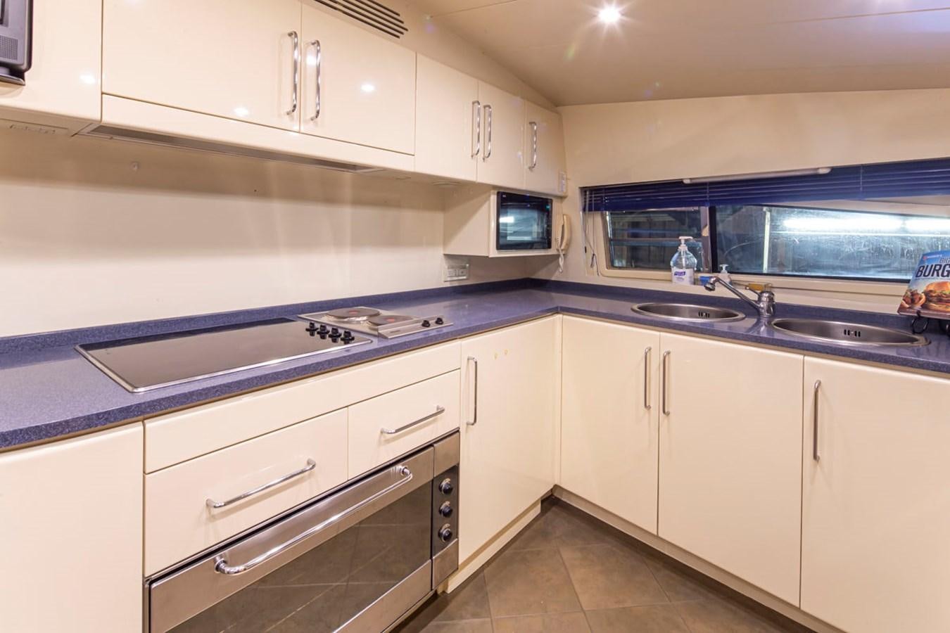 a kitchen with white cabinets aboard WILD WAVES Yacht for Sale