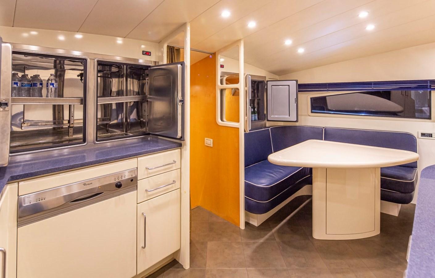 a kitchen with a table and a couch aboard WILD WAVES Yacht for Sale