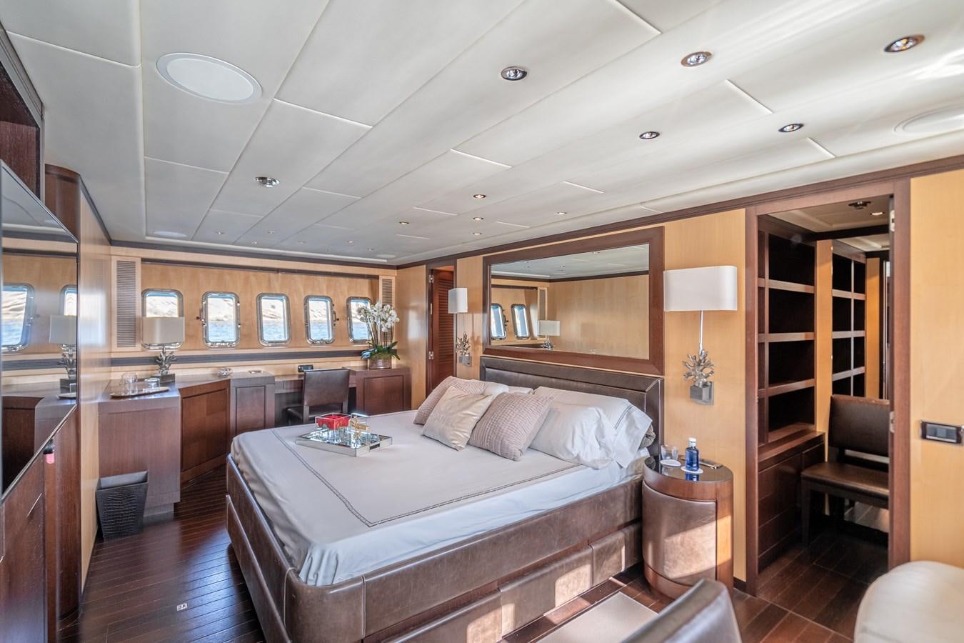 a bedroom with a bed and a desk aboard FIVE STARS Yacht for Sale