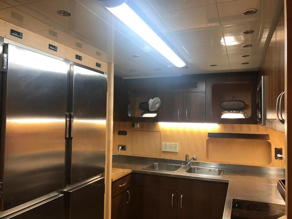 a kitchen with a stainless steel refrigerator aboard FIVE STARS Yacht for Sale