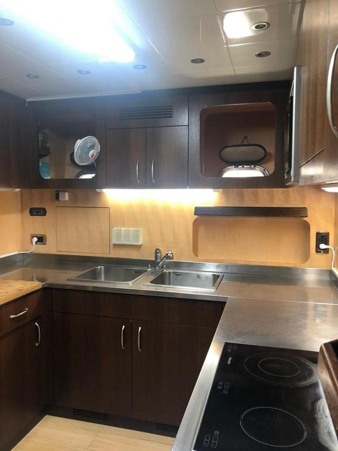 a kitchen with wooden cabinets aboard FIVE STARS Yacht for Sale