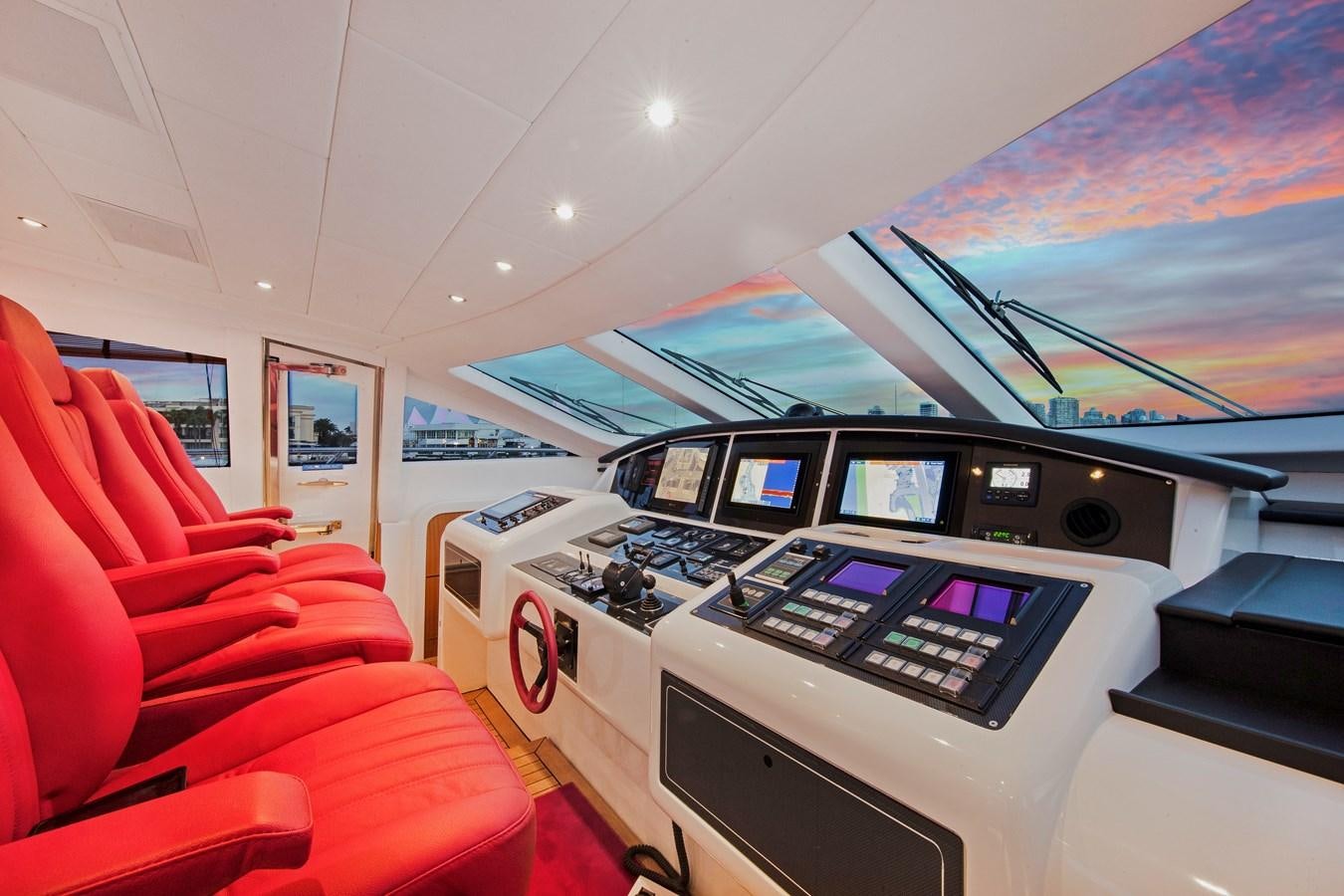 a room with red seats and a row of computer monitors aboard VANISH Yacht for Sale