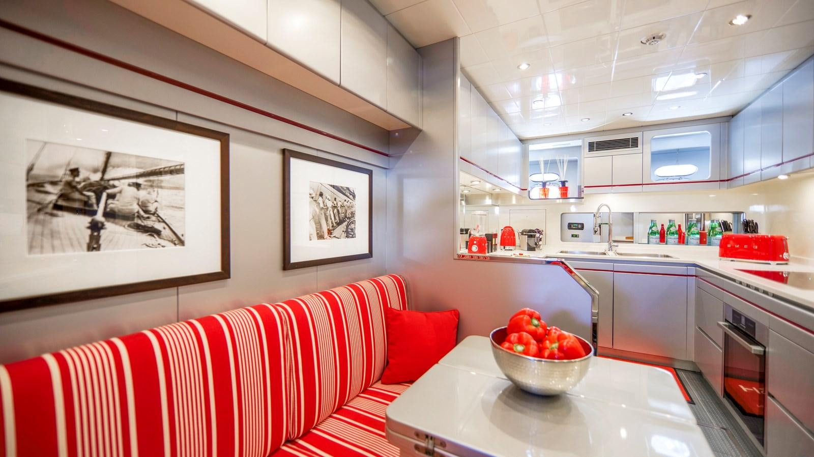a kitchen with a red couch aboard VANISH Yacht for Sale