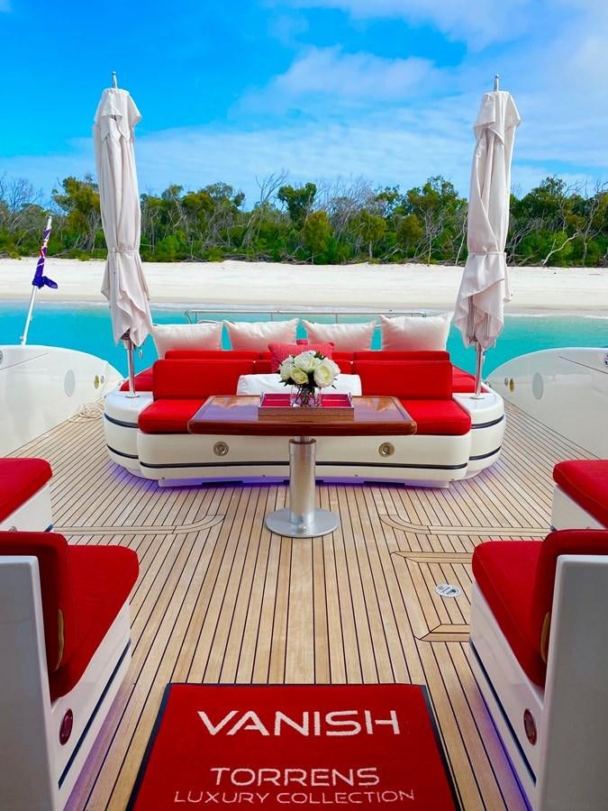 a table with red chairs and red and white tablecloths aboard VANISH Yacht for Sale