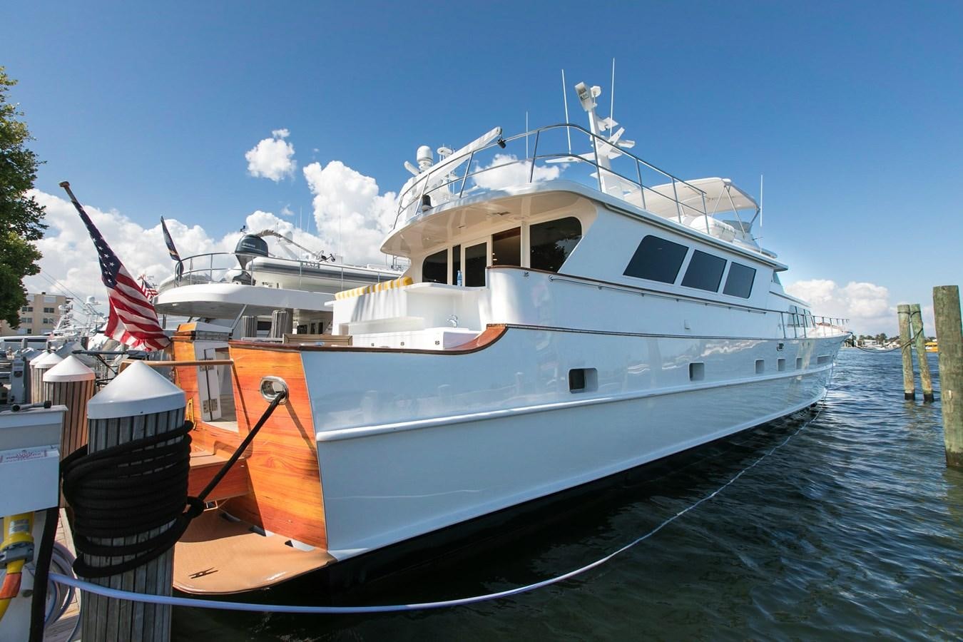 a large white boat with a flag on it aboard TRES HERMANOS VI Yacht for Sale