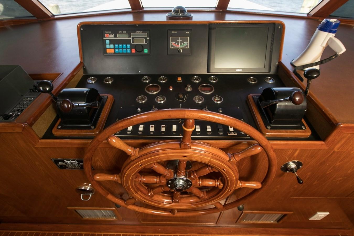 a wooden steering wheel and dashboard of a car aboard TRES HERMANOS VI Yacht for Sale