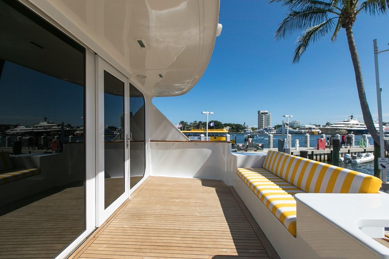 a deck with a bench and a tree by a body of water aboard TRES HERMANOS VI Yacht for Sale
