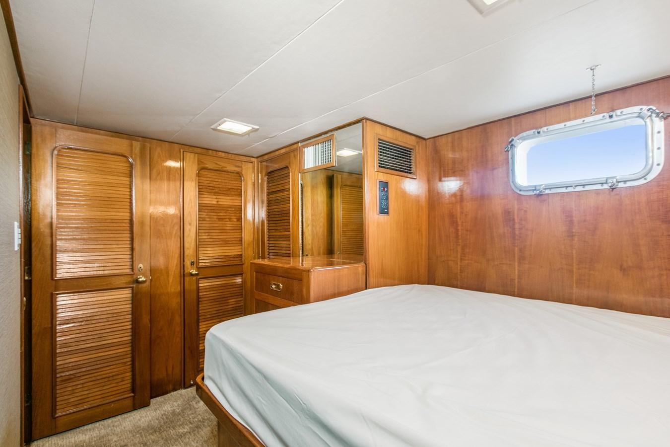 a room with a bed and a closet aboard TRES HERMANOS VI Yacht for Sale